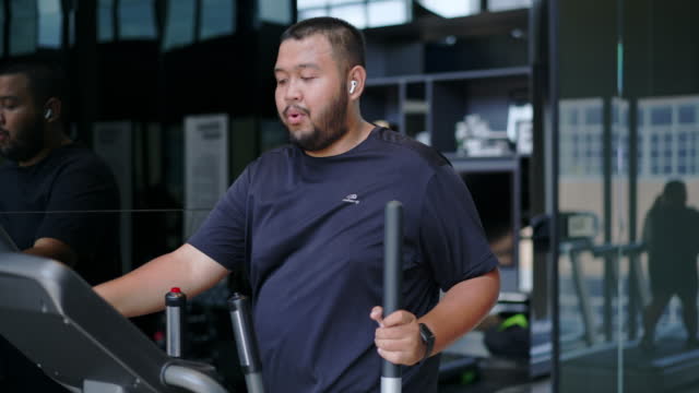 Man exercising on an elliptical machine to lose weight