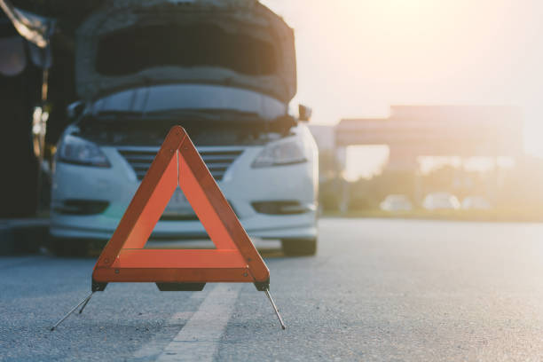 Red emergency sign on a rural road car broken down on highway road safety concept stock photo