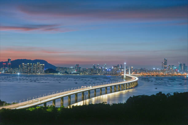 Brightly lit Shenzhen high-rise buildings and Shenzhen Bay Bridge.
