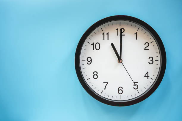 istock Classic black and white analog clock on blue background at Eleven o'clock with copy space 1409664538