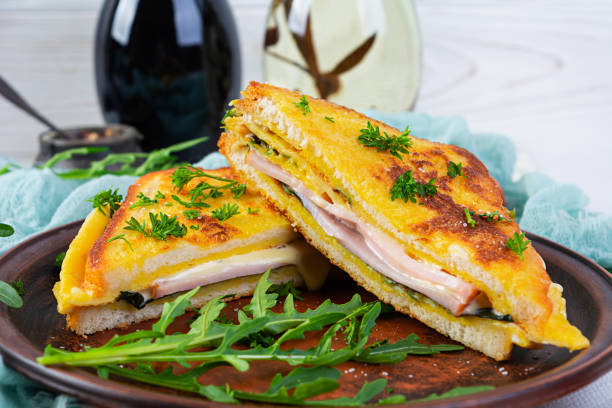 istock Roasted toast in scrambled eggs with ham, herbs and cheese cheddar. Delicious grilled breakfast sandwich 1409665501