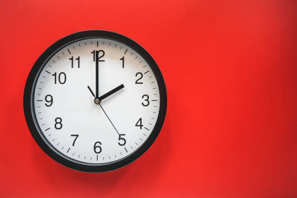 istock Classic black and white analog clock on red background at Two o'clock with copy space 1409665939