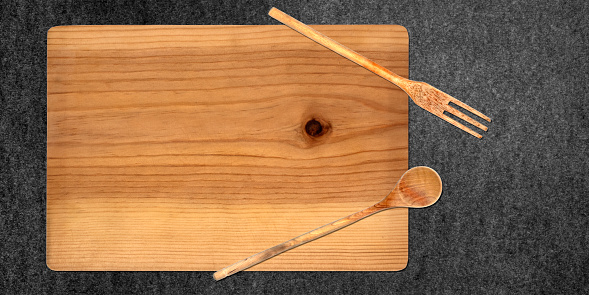 Topview of Cutting Board and Set Cooking Utensils on Dark Background