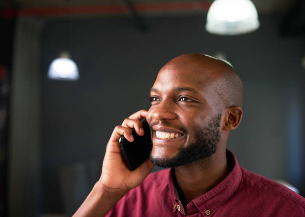 istock A Black man smiles on a cellphone call in the office 1409666459