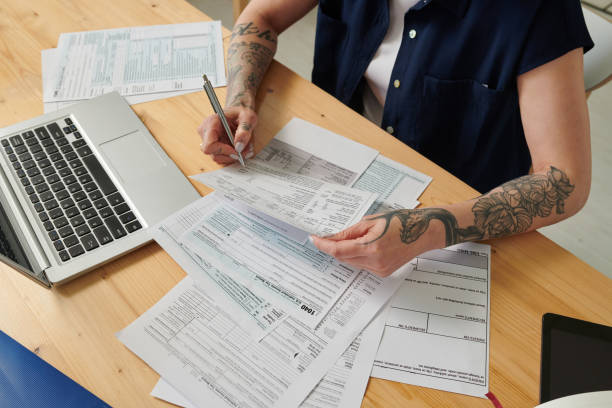 istock Woman signing payed bills at table 1409668243