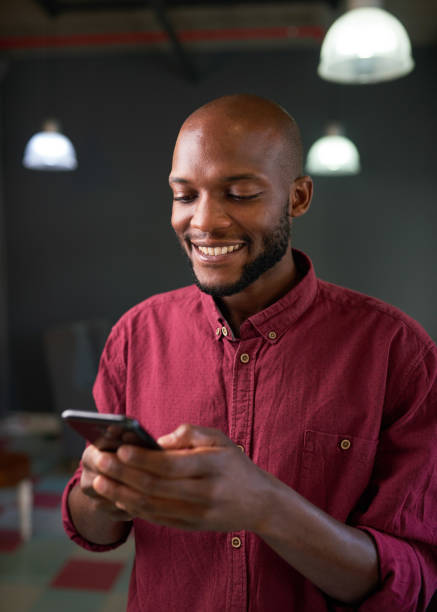 istock An attractive Black man texts on his phone and smiles 1409669403