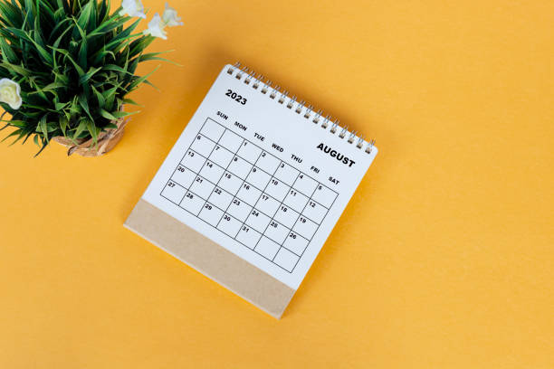 istock August 2023 desk calendar on yellow background. Directly above. Flat lay. 1409671378