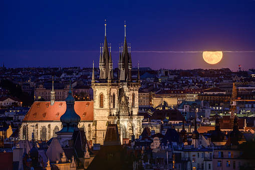 La súper luna llena de 2022 sobre la Iglesia de Nuestra Señora ante Týn en Praga. photo