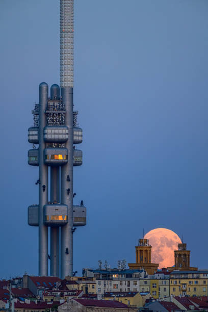 la pleine lune montante au-dessus du paysage urbain de prague avec la tour de télévision zizkov. - full moon audio photos et images de collection