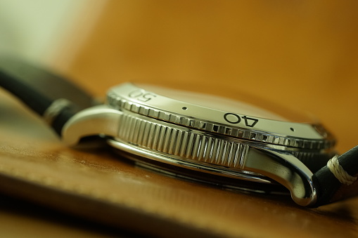 Side view of a stainless steel wristwatch selectively focused on the fluted case and part of the bezel showing number 40.