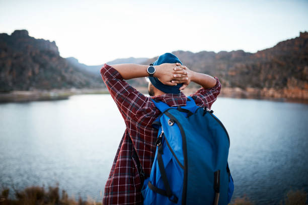 istock A hiking man takes a break and admires lake view while backpacking the mountains 1409676458