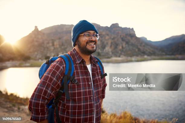 A Young Adult Backpacker Smiles At The Lake View With Sunset In The Mountains Stock Photo - Download Image Now