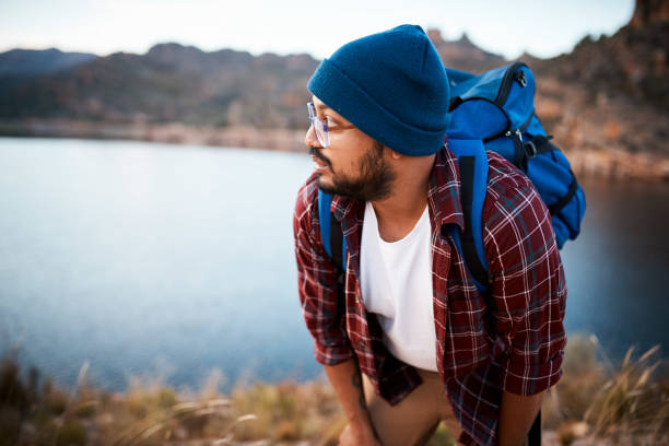 istock A hiker takes a break while climbing up a mountain with lake view 1409678732
