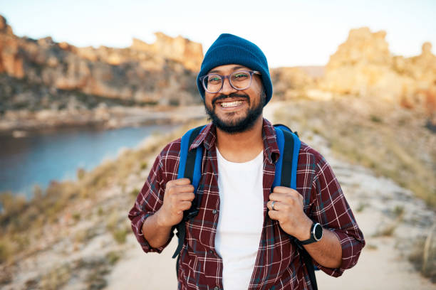 istock An attractive hiker smiles with backpack in the mountains at sunset 1409679552
