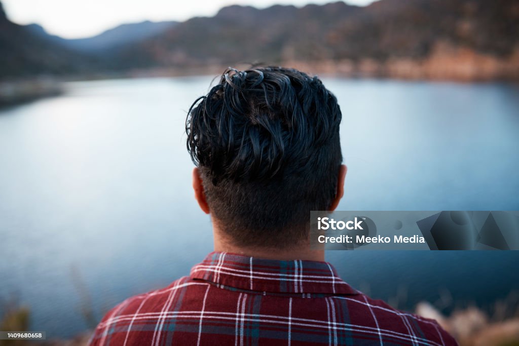 The back of a man's head while he admires the lake view on camping mountain trip The back of a man's head while he admires the lake view on camping trip in the mountains. High quality photo Back Of Head Stock Photo