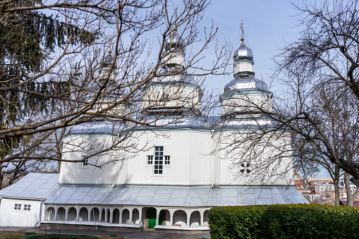 facade of a wooden Christian church with three domes and crosses.