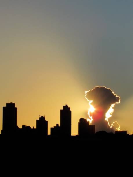 istock sun starting to set between the cloud and the buildings. 1409690320