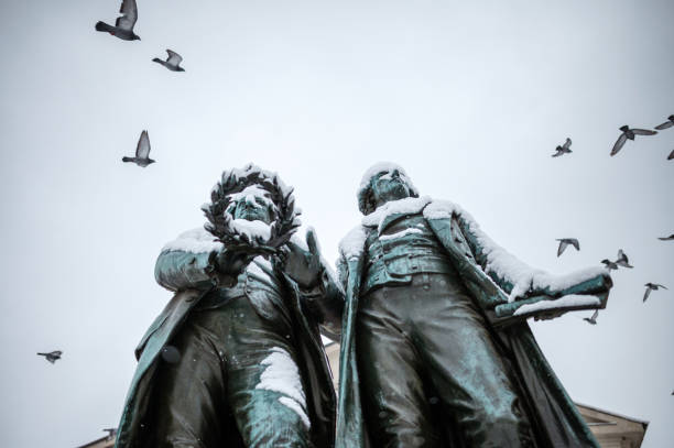 Weimar, Germany - January 03, 2021: The Goethes Schiller Monument on Weimar's Theatre Square in front of the German National Theatre was created by the Dresden sculptor Ernst Rietschel in 1857 and depicts the two poets Johann Wolfgang von Goethe and Friedrich Schiller.