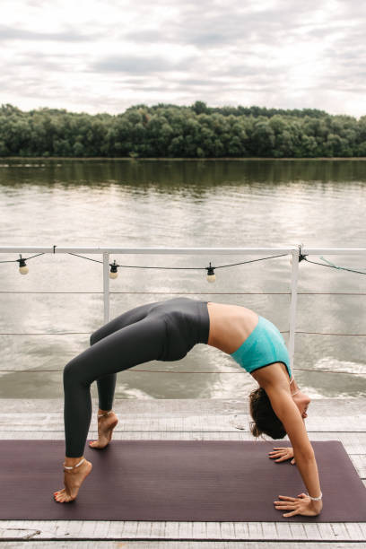 istock Woman doing yoga by the river 1409691932