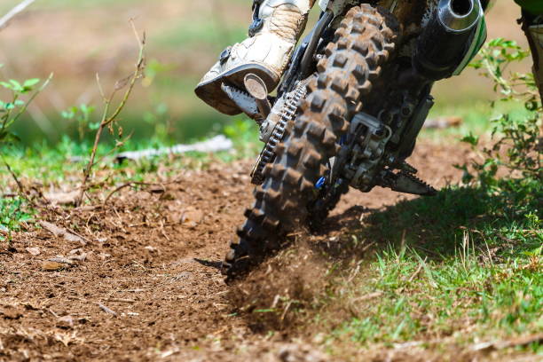 enduro rides through the mud with big splash,driver splashing mud on wet and muddy terrain,Motocross racer in a wet and muddy terrain covering the driver completely.
