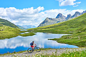 senior woman on electric bicycle in Silvretta mountains, Tirol, Austria