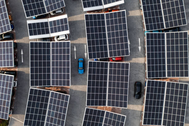 Aerial view of solar panels on a parking lot rooftop Aerial view directly above electric cars parking under solar panels on a parking lot rooftop ready for charging battery storage stock pictures, royalty-free photos & images