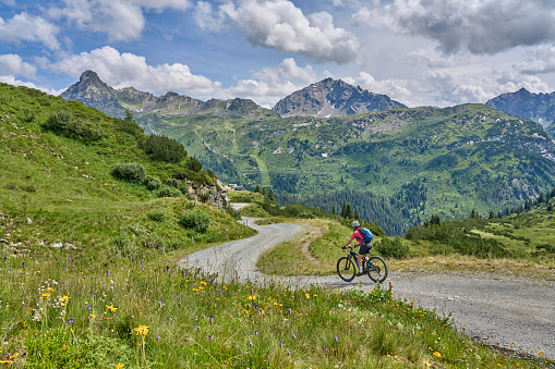 nice active senior woman riding her electric mountain bike in the silvretta mountain range near Gaschurn, Tyrol, Austria