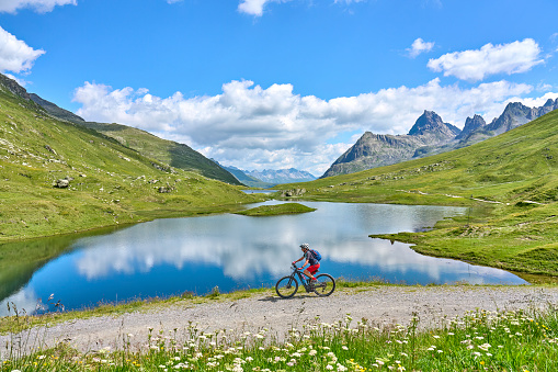 nice active senior woman riding her electric mountain bike in the silvretta mountain range near Gaschurn, Tyrol, Austria