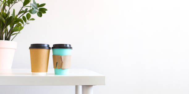 two cardboard cup of hot drink for take away on white table. Concept break, drinking coffee with friends, morning ritual, copyspace, banner.