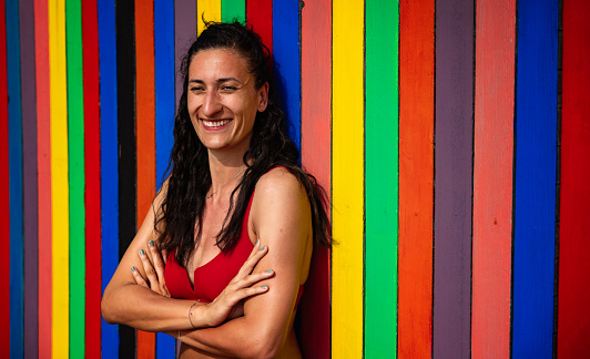 Portrait of carefree young Caucasian woman in swimwear i front of the multi-colored background