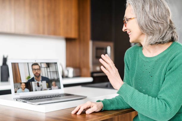 istock Serious waving at laptop with people profiles 1409708387