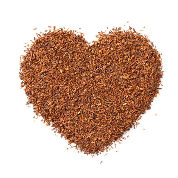 rooibos secos, chá de arbusto, chá vermelho, folhas de chá redbush em forma de coração em fundo branco de perto - heart shape isolated isolated on white tea leaves - fotografias e filmes do acervo