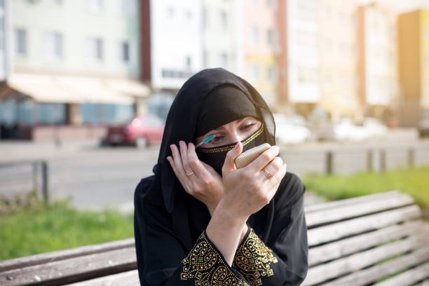 istock Woman paints her eyes while sitting on a bench on the street 1409708582