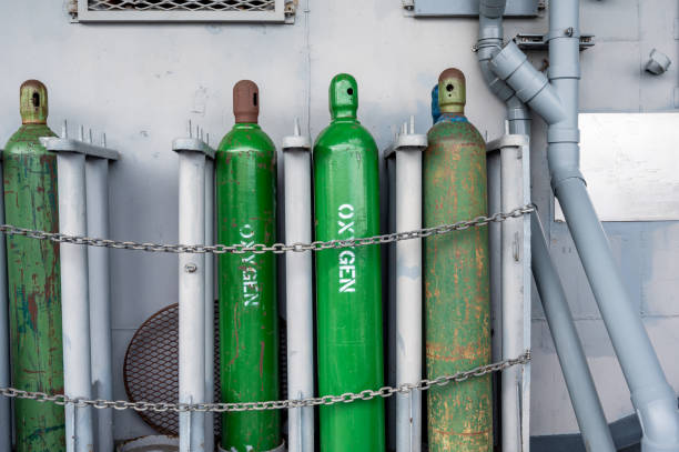 istock Compressed gas cylinders being stored vertically secured by a metal chain and a metal cap. 1409710654