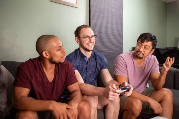 istock Three Guys Hanging Out Playing Video Games 1409711519