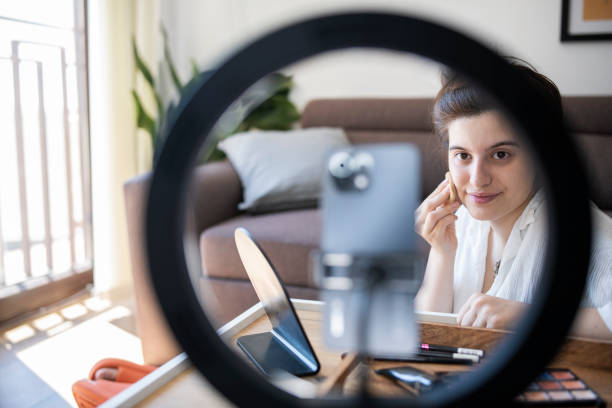 istock Woman giving make-up tutorial on mobile phone at home. 1409711544