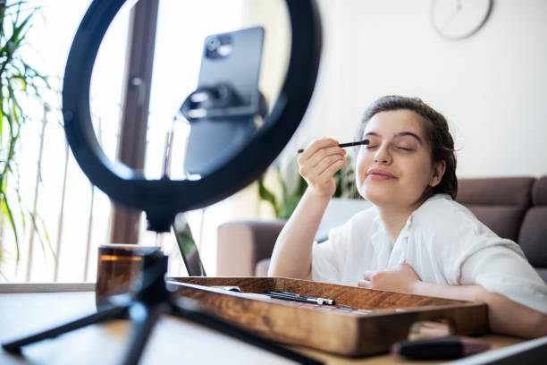istock Woman giving make-up tutorial on mobile phone at home. 1409711551