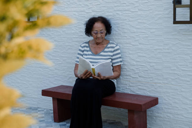 istock Elderly brazilian woman reading a book 1409712060