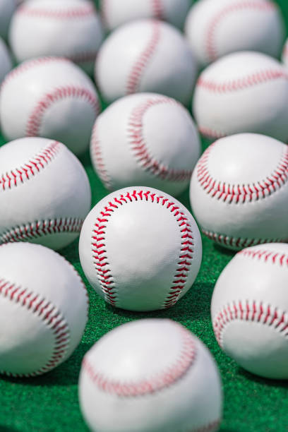 istock Low angle view of new baseballs in a row on a green carpet 1409716882