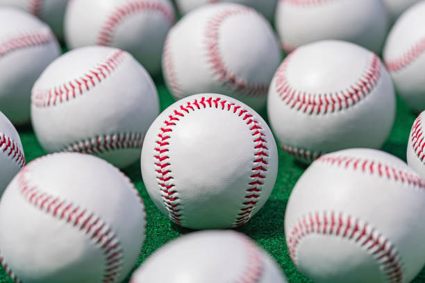istock Low angle view of new baseballs in a row on a green carpet 1409716906