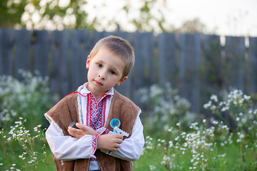 Slavic little boy Belarusian or Ukrainian in national clothes on a rustic background.