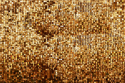 Golden rainbow background from small squares. Iridescent golden glass texture background. Multicolored icy shiny crystal texture. Abstract iridescent texture.