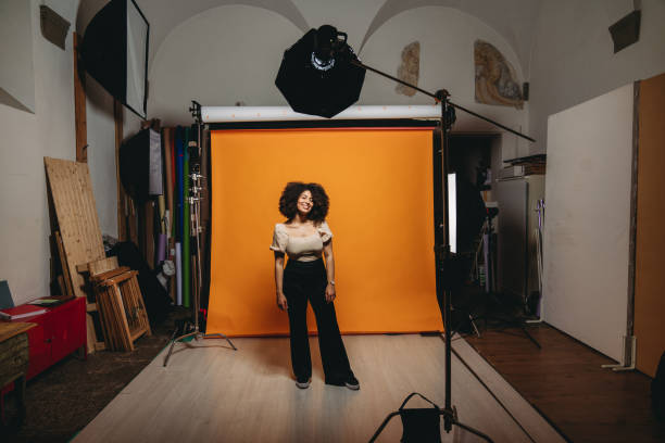 BTS shot of a model in a photo studio BTS shot of a model in a photo studio. Mixed race with afro hair. photo shoot stock pictures, royalty-free photos & images