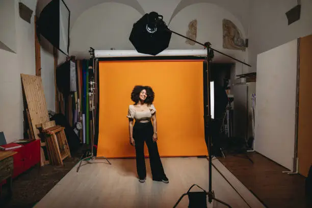BTS shot of a model in a photo studio. Mixed race with afro hair.