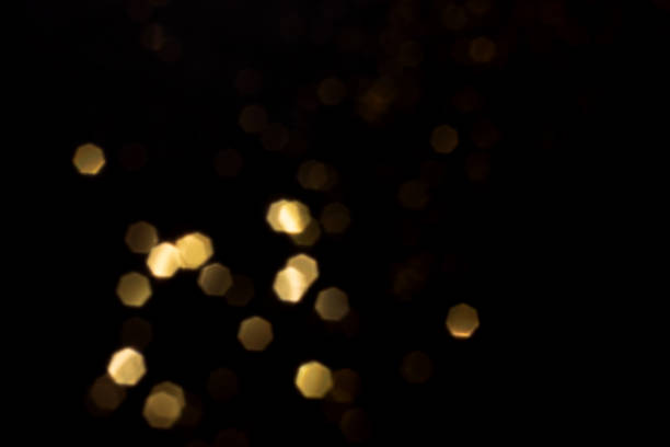 istock Golden blurred bokeh lights on black background 1409727082