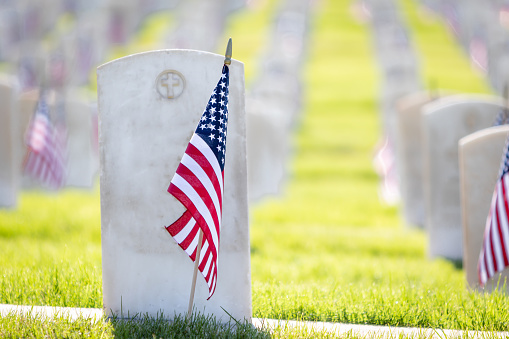 Military headstones honoring armed forces servicemen decorated with American flags for Memorial Day