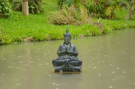 Maquine, Rio Grande do Sul, Brazil - May 29th, 2016: Buddha sculpture on a pond in a rainy day