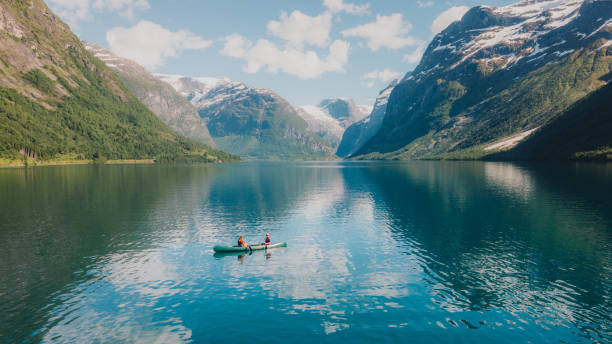 vista aérea de mujer y hombre contemplando el verano en noruega en canoa en el lago lovatnet - fiordo fotografías e imágenes de stock