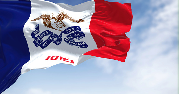 the flag of Iowa waving in the wind on a clear day. Iowa is a state located in the midwestern region of the United States. Democracy and independence.