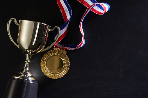 medal and and trophy on blackboard  with copy space